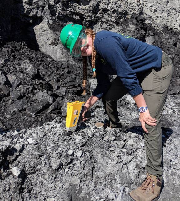 炭鉱の埋蔵物を調査するためにXRFガンを使用する科学者