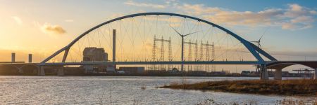 Bridge and a wind turbine with steel towers in the background